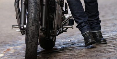 Biker trägt City Motorradschuhe und schiebt sein Motorrad