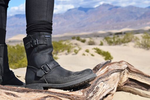 Frau trägt Stiefel von Falco und steht auf einem Stein