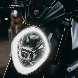 Frontansicht eines Ducati Monster LED-Scheinwerfers mit modernem, ovalem Design und leuchtendem Lichtkranz.