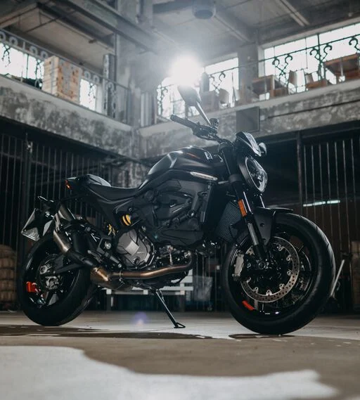 Schwarze Ducati Monster in einer industriellen Halle, stilvoll präsentiert mit modernem Design und sportlicher Optik.